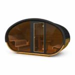 Sauna extérieur en bois 9 Sauna ovale TimberIN Nordic Hobbiton Glass, avec coque en bardeaux foncés, façade panoramique vitrée, porte centrale et banquettes courbes sur fond blanc