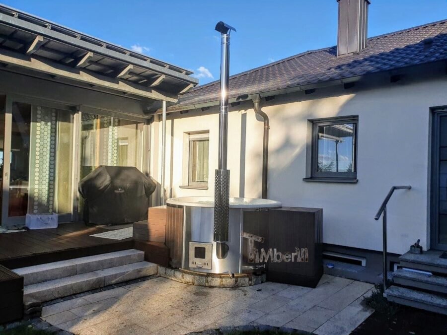 Bain nordique avec poêle extérieur et cheminée sur une terrasse