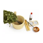 Accessoires pour bains nordiques 11 Ensemble d’accessoires de sauna Harvia avec seau et louche en bois, branches de bouleau, thermomètre-hygromètre, huile essentielle et bol en cuivre sur fond blanc