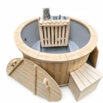 Bain nordique 12 Bain nordique rond TimberIN Nordic Compact Snorkel avec cuve grise, poêle-tuba interne protégé, cheminée et plateforme d’accès en bois sur fond blanc