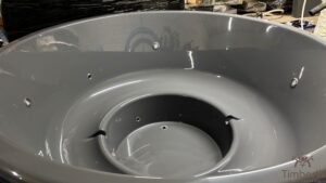 Éclairage sous-marin LED dans un bain nordique, sur plateforme d'exposition surélevée, avec cuve intérieure moulé gris foncé