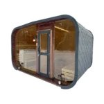 Sauna extérieur en bois 12 Sauna de jardin contemporain TimberIN Nordic Horizon, avec toiture sombre arrondie, façade panoramique vitrée et banquettes intérieures visibles sur fond blanc