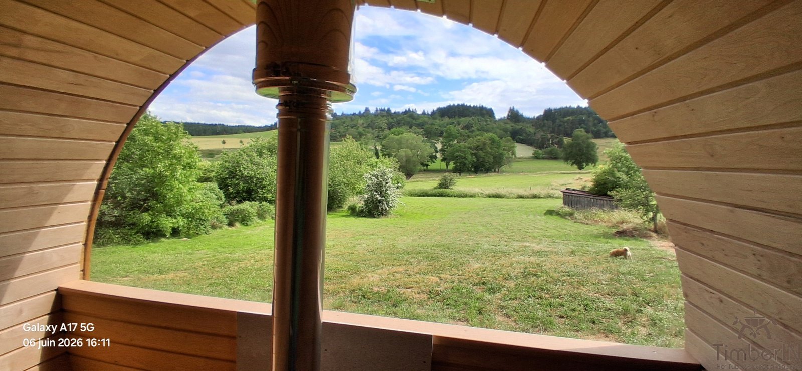 Projet client : préparer deux zones pour un sauna tonneau et un bain nordique 4 Vue depuis l’intérieur d’un sauna tonneau TimberIN vers le jardin