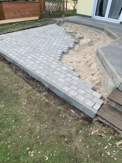 Installation d’un bain nordique 18 Pavés nouvellement posés sur la base préparée près d’une terrasse de maison