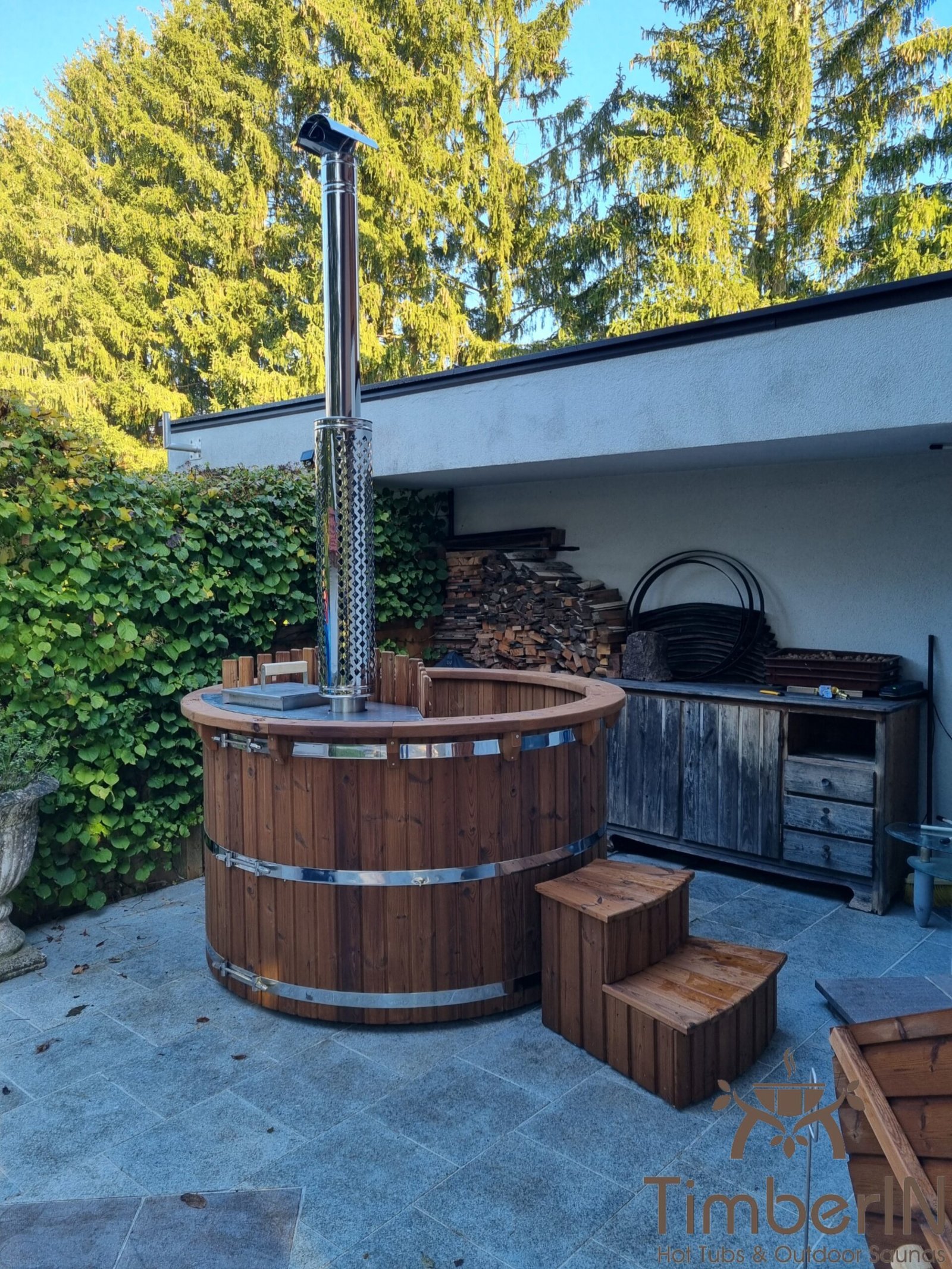 Types de bois pour bain nordique 1 Bain nordique rond en bois thermotraité brun avec marches sur une terrasse