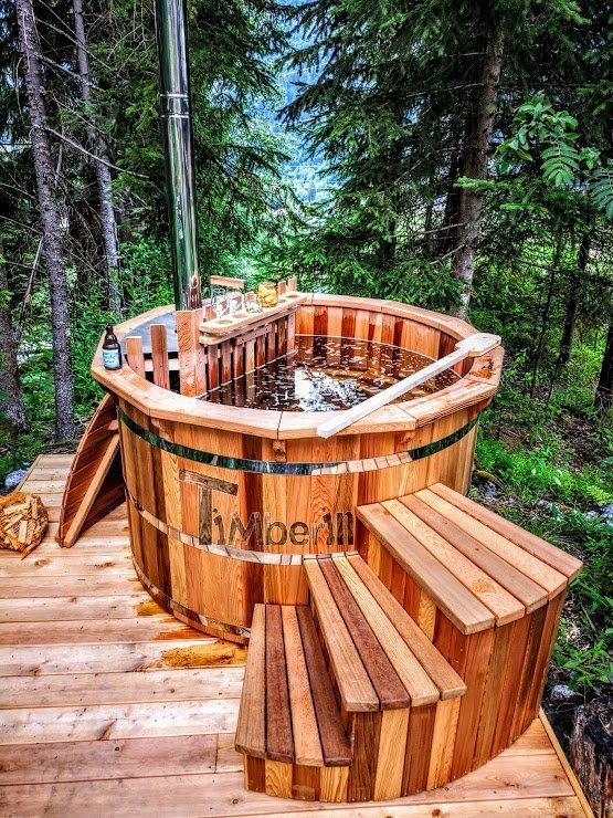 Types de bois pour bain nordique 4 Bain nordique rond en cèdre rouge avec marches sur une terrasse boisée
