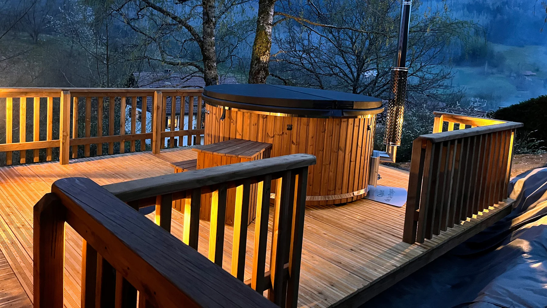 Jacuzzi® bois : comprendre la recherche 1 Bain nordique en bois TimberIN chauffé le soir sur une terrasse