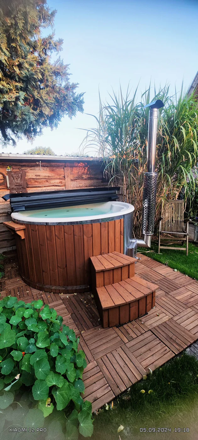 Conduit vertical d’un poêle extérieur installé près d’un bain nordique TimberIN