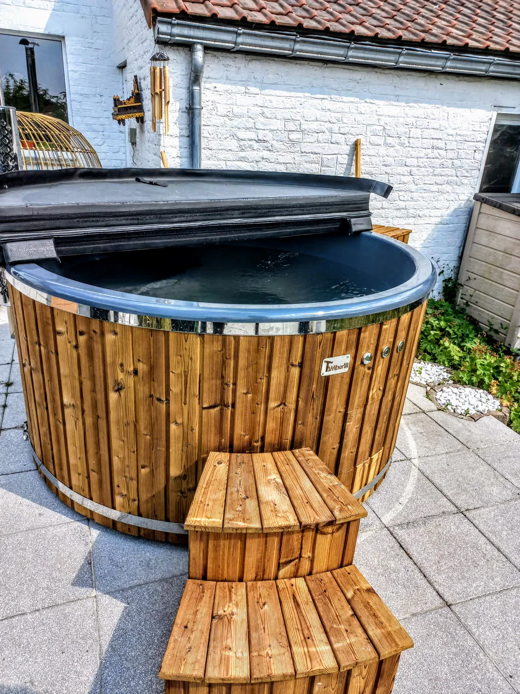 Choisir un couvercle de bain nordique : isolation, manipulation, pluie et durée de vie 2 Couvercle rigide posé sur un bain nordique TimberIN