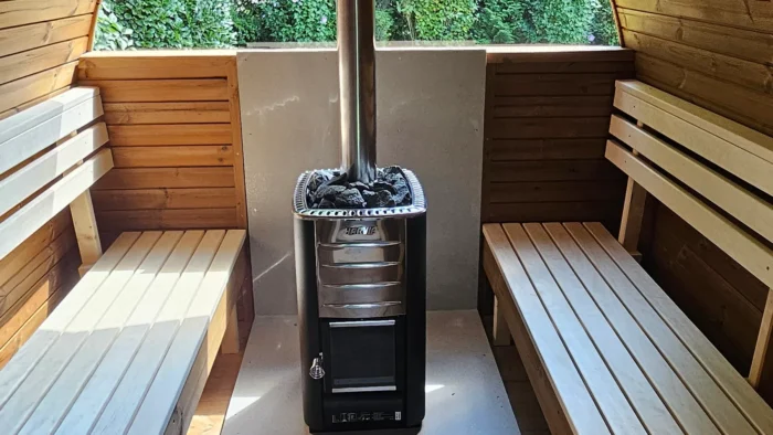 Poêle et bancs à l’intérieur d’un sauna extérieur TimberIN