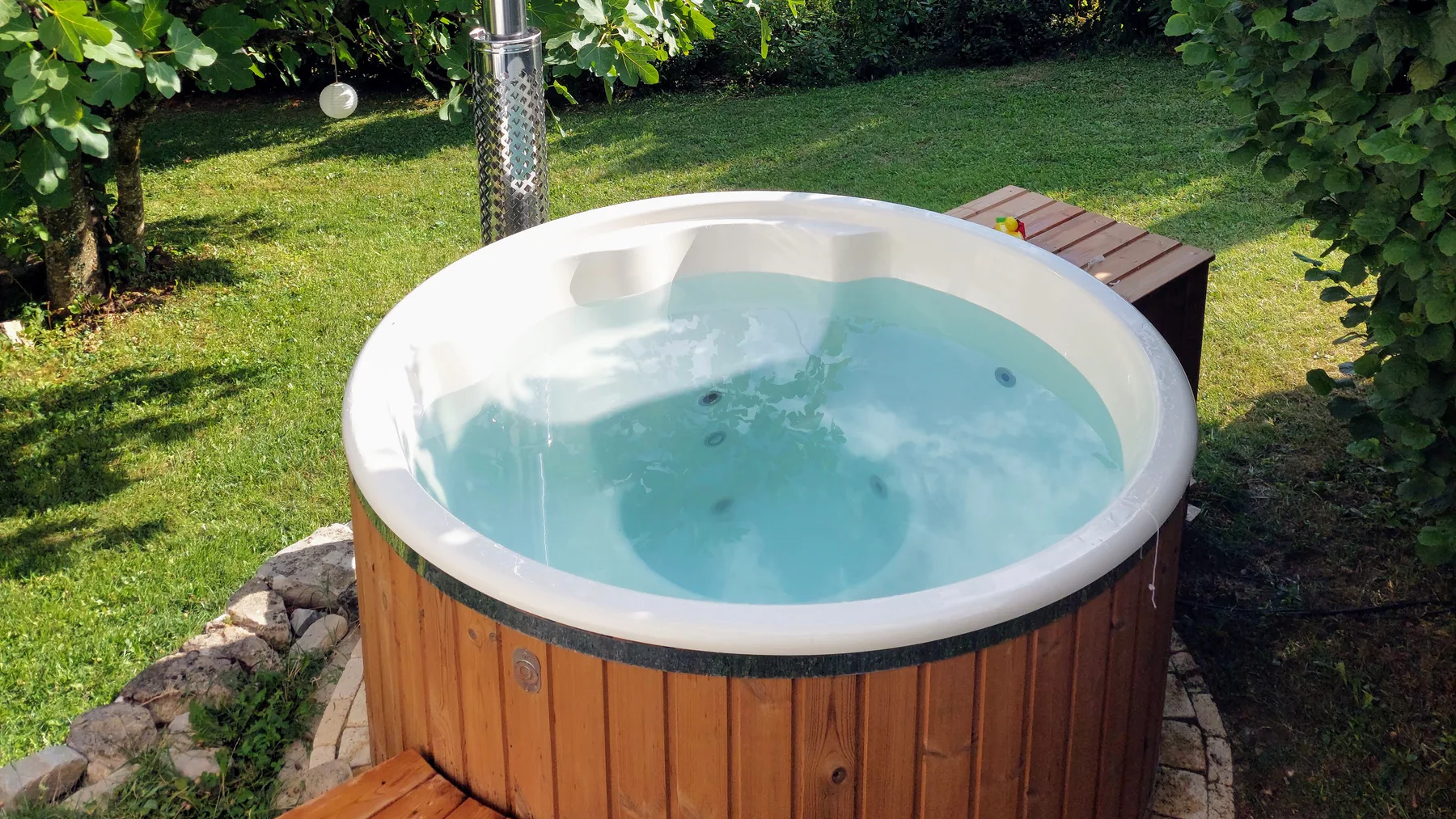 Bain nordique TimberIN rempli d’eau dans un jardin