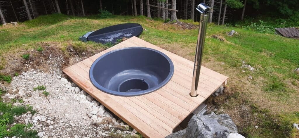 Préparation du terrain pour bain nordique 21 Cheminée d’un poêle à bois installée à côté d’un bain nordique encastré