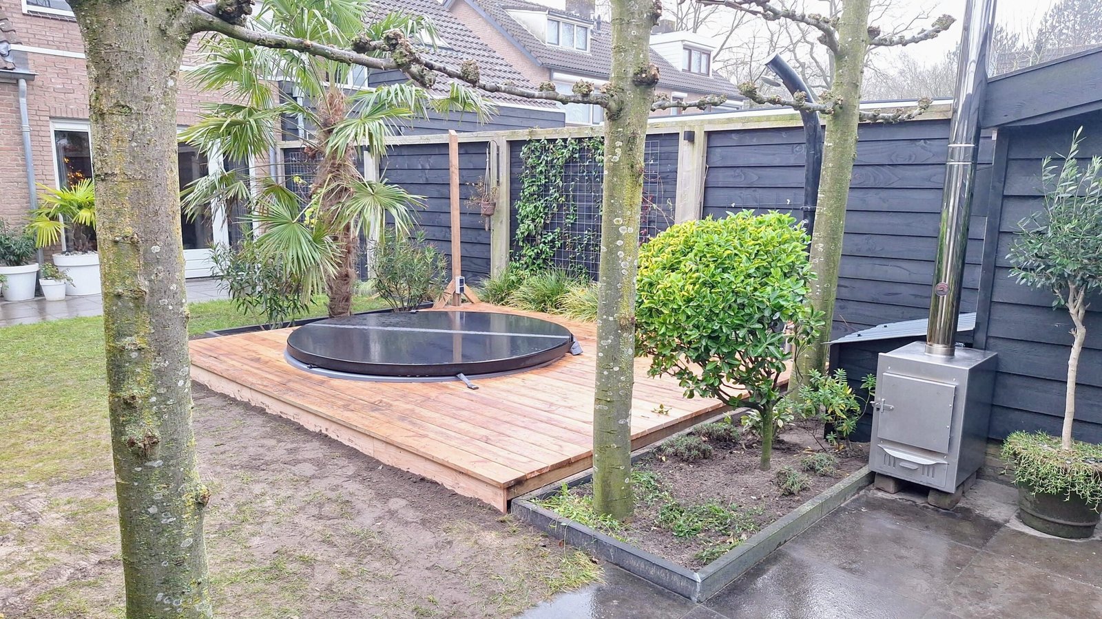 Bain couvert intégré à une terrasse de jardin avec un poêle extérieur séparé