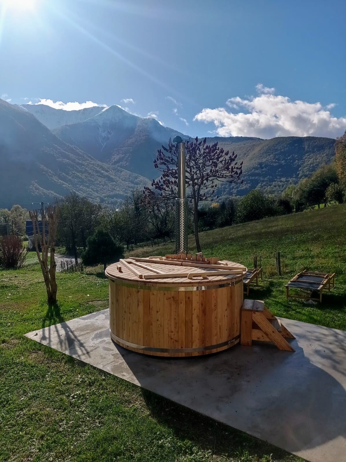 Bain nordique en bois sur une dalle, avec un paysage de montagne