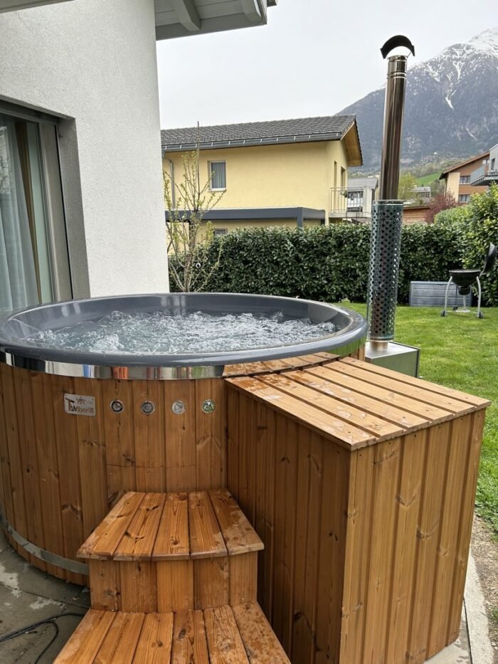 Bain nordique installé à l’extérieur avec marches et cheminée