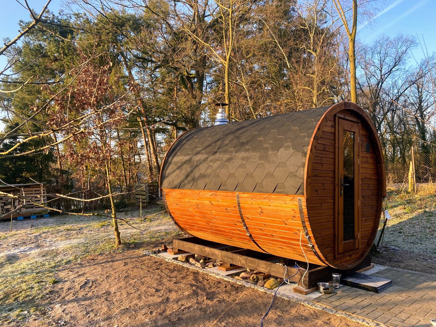 Sauna extérieur en bois 1 Sauna tonneau en bois installé dans un jardin
