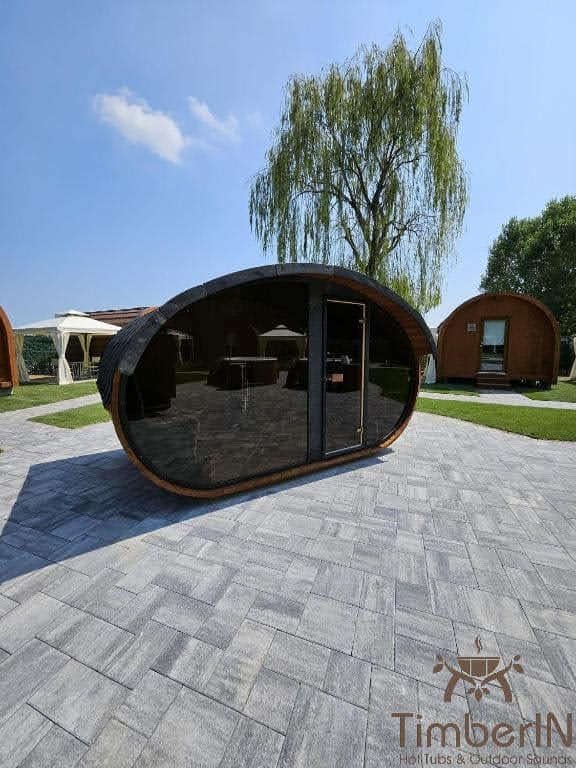 Sauna extérieur design 1 Sauna à façade vitrée ovale présenté sur une surface pavée