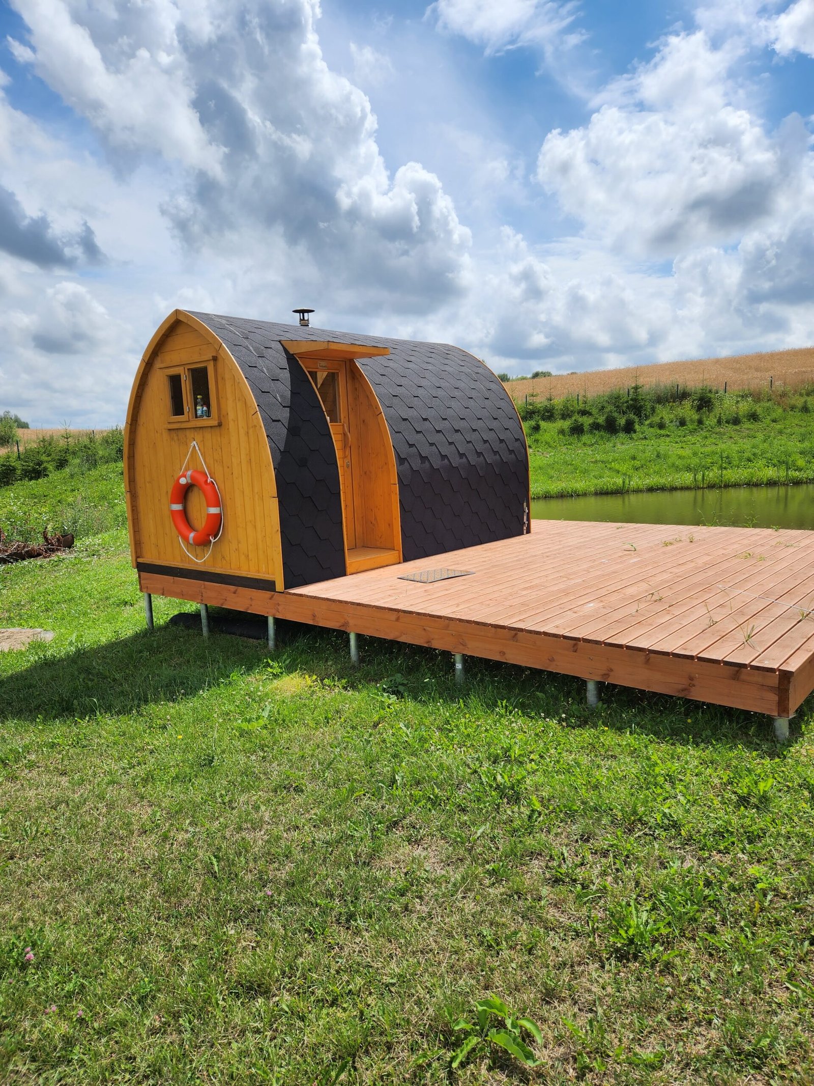 Sauna de jardin 1 Sauna en bois posé sur une terrasse près d’un étang
