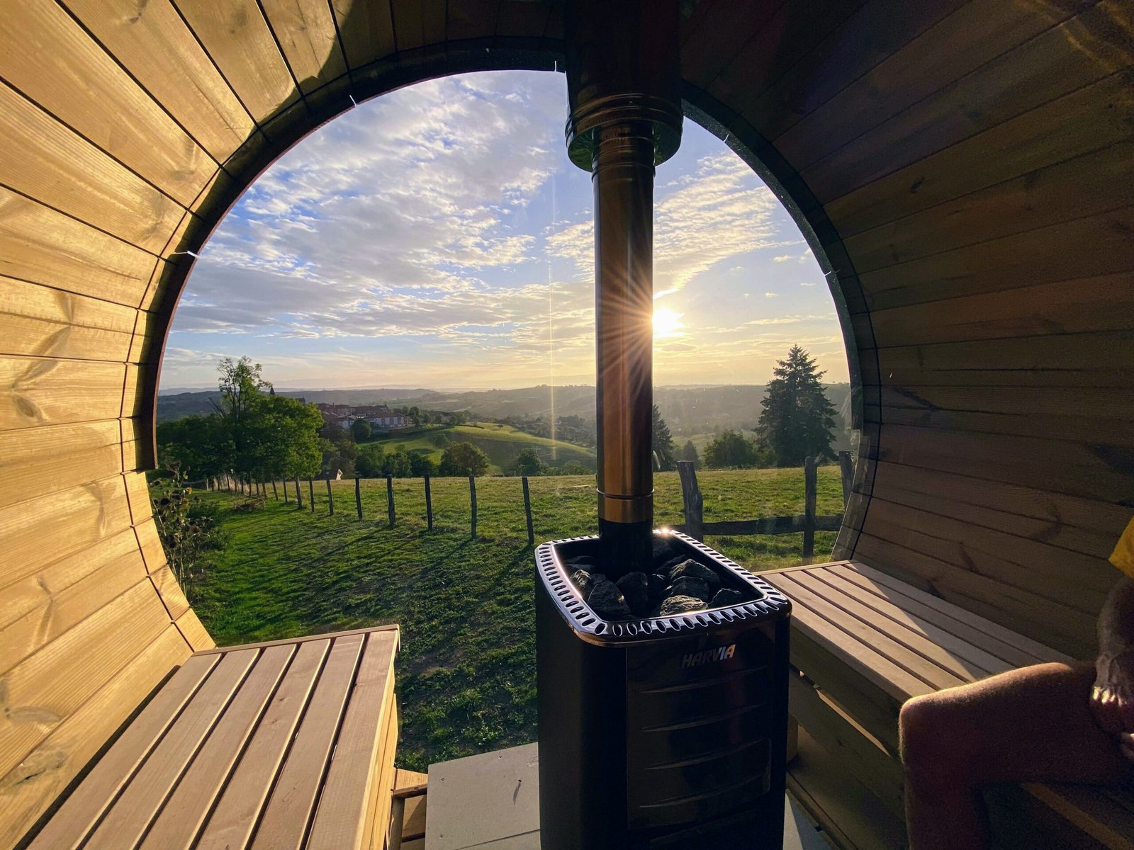 Poêle à bois et conduit entre les bancs d’un sauna panoramique