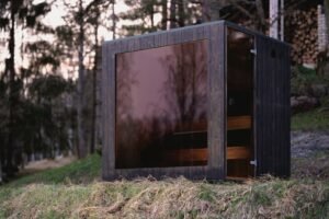 TimberIN Nordic Cube avec façade vitrée teintée en forêt