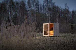 TimberIN Nordic Cube sauna éclairé le soir en forêt